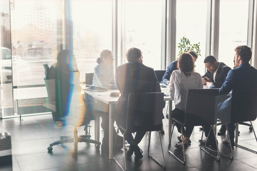 Staffing Solutions - Group of Co Workers Discussing a Problem at a Conference Table