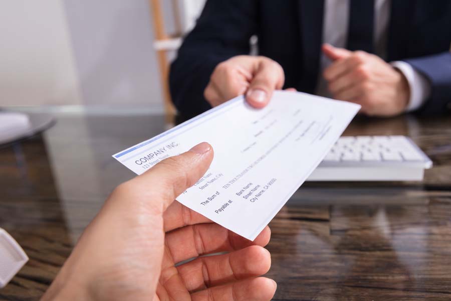 Payroll Solutions - Man Handing Co Worker a Check for Work for the Week